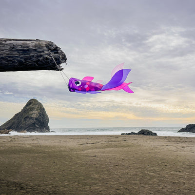 15-inch Lavender Damsel Fish windsock displaying colorful fins fluttering in the breeze against a garden backdrop.