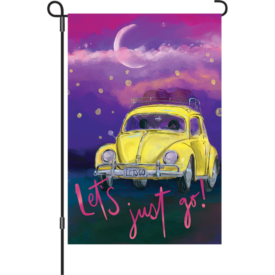 12 in. Let's Just Go garden flag with a Volkswagen Beetle and fireflies against a starry sky, displayed outdoors in a garden setting.