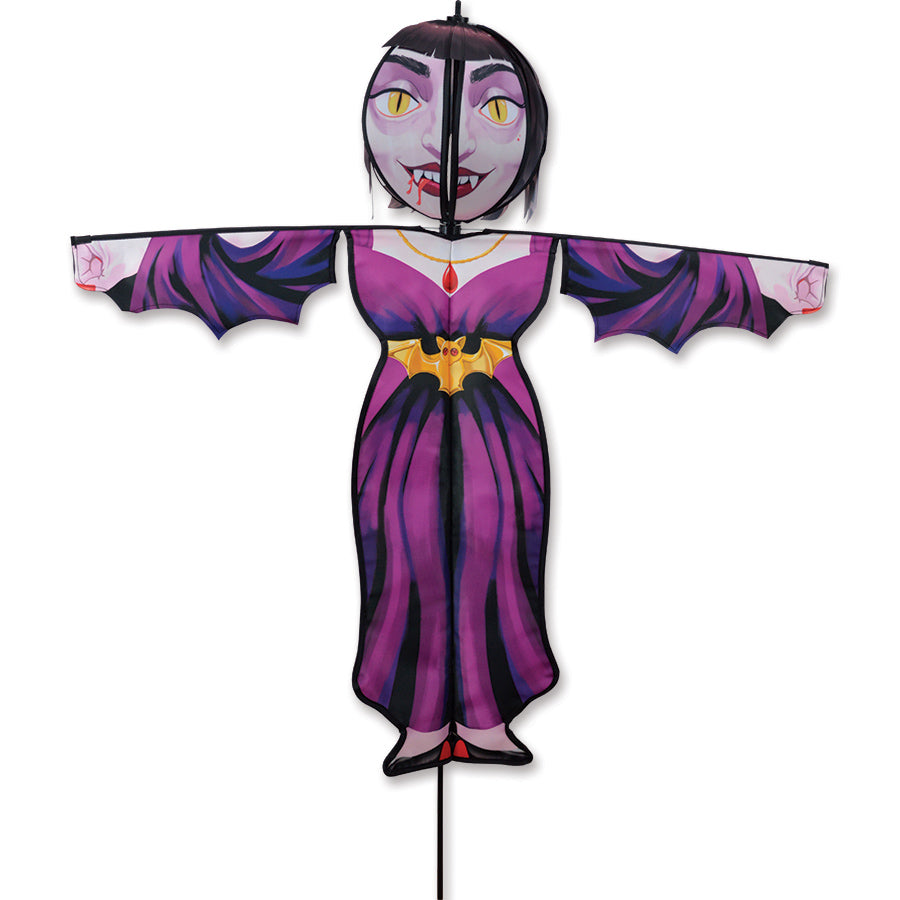 Lg. Spinning Friend - Vampire Countess yard spinner with spooky design and spinning head installed in an outdoor garden setting.