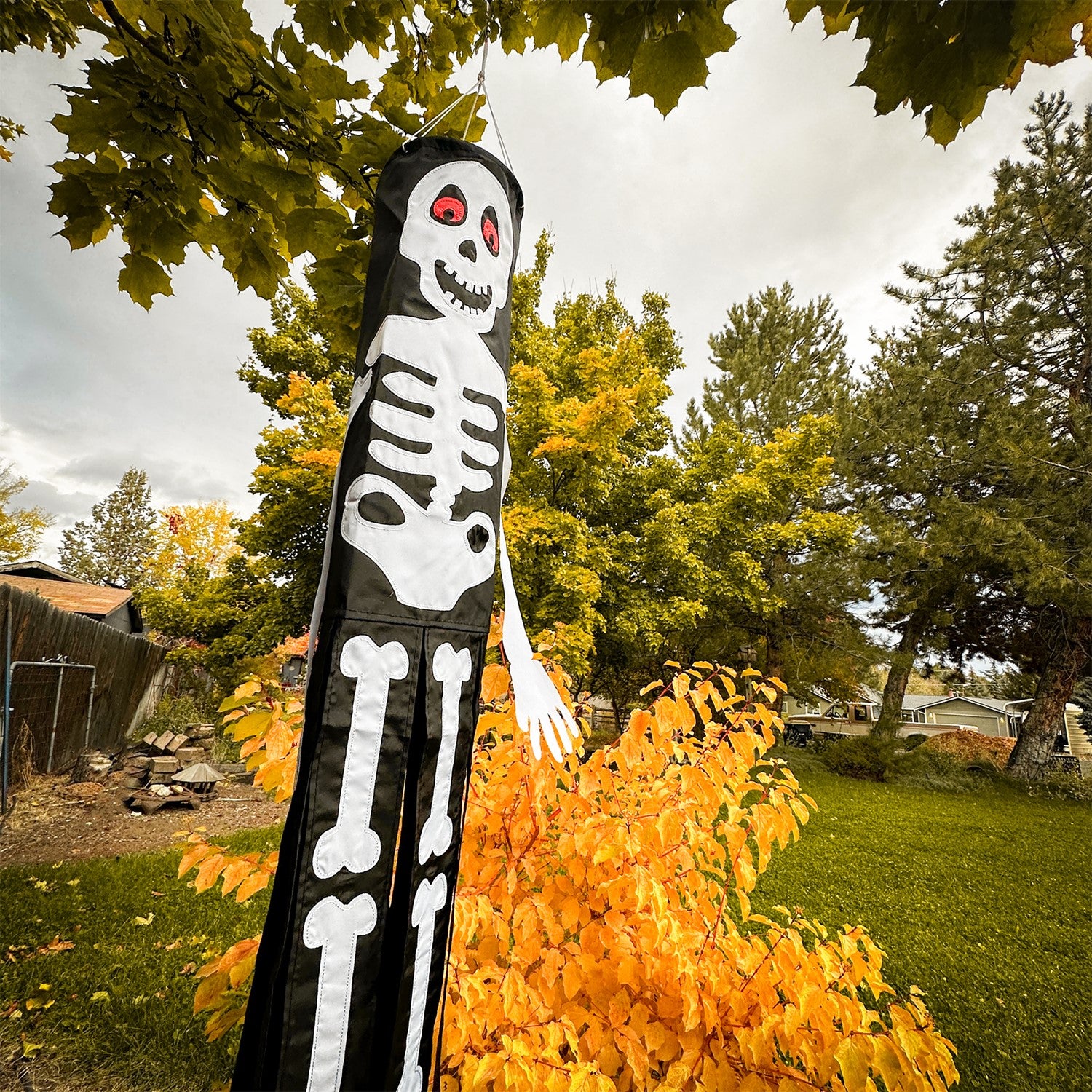 Lil' Bones Skeleton 3D windsock, 40 inches long, featuring playful applique skeleton bones and vibrant fluttering tails against a backdrop of blue sky.