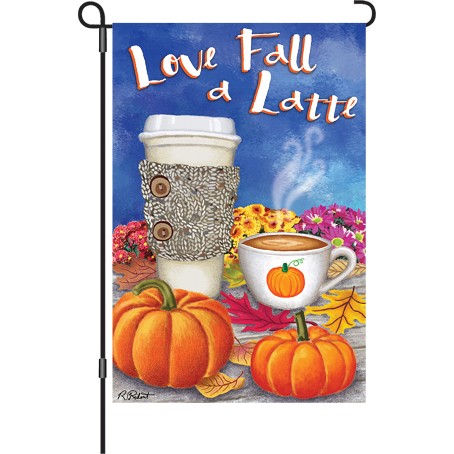 12 in. Love Fall a Latte garden flag with vibrant autumn-themed design displayed in a garden setting, swaying gently in the breeze.
