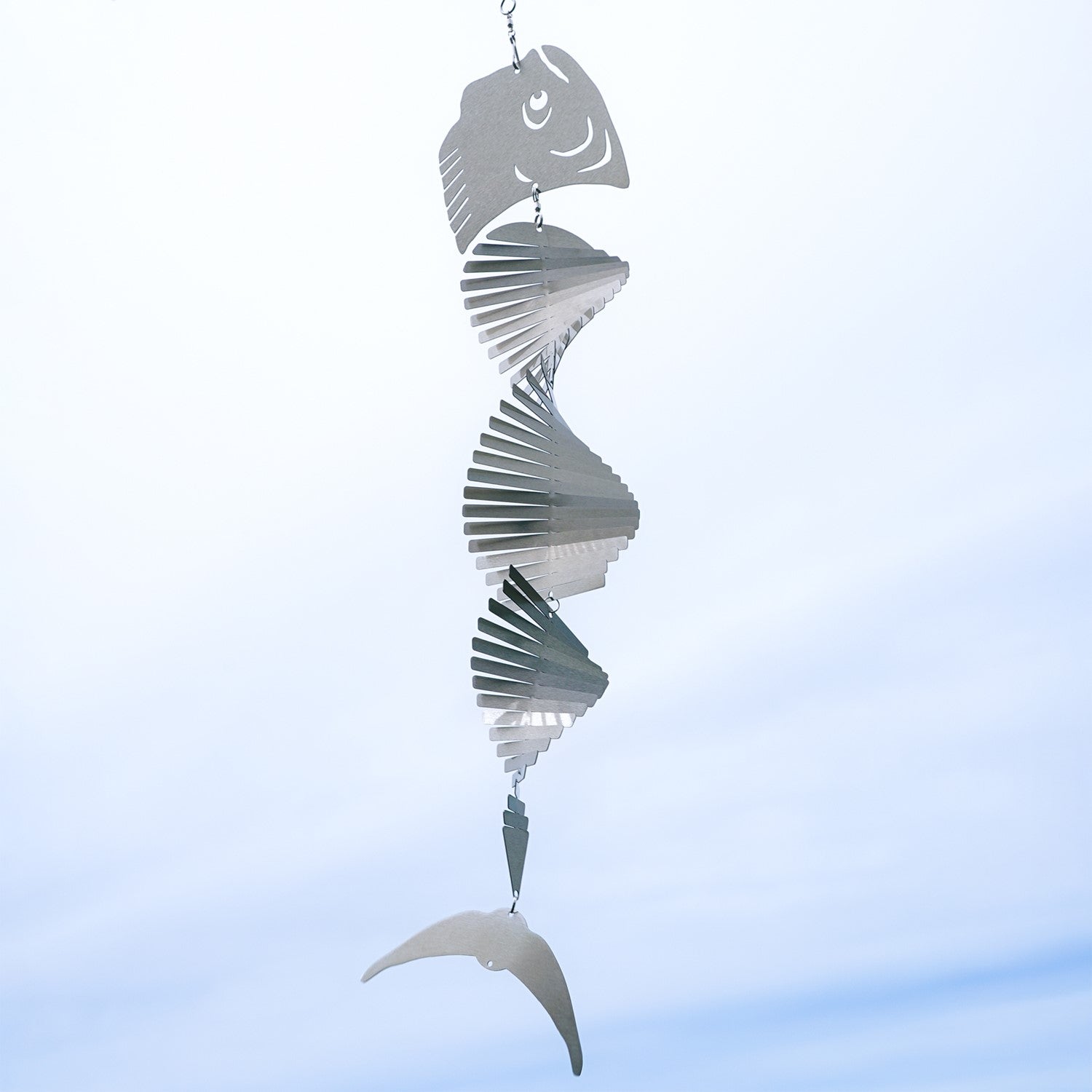 Mahi-mahi Shimmer Helix Spinner made of stainless steel, showcasing a helix design with shimmering fish head and tail, displayed outdoors.
