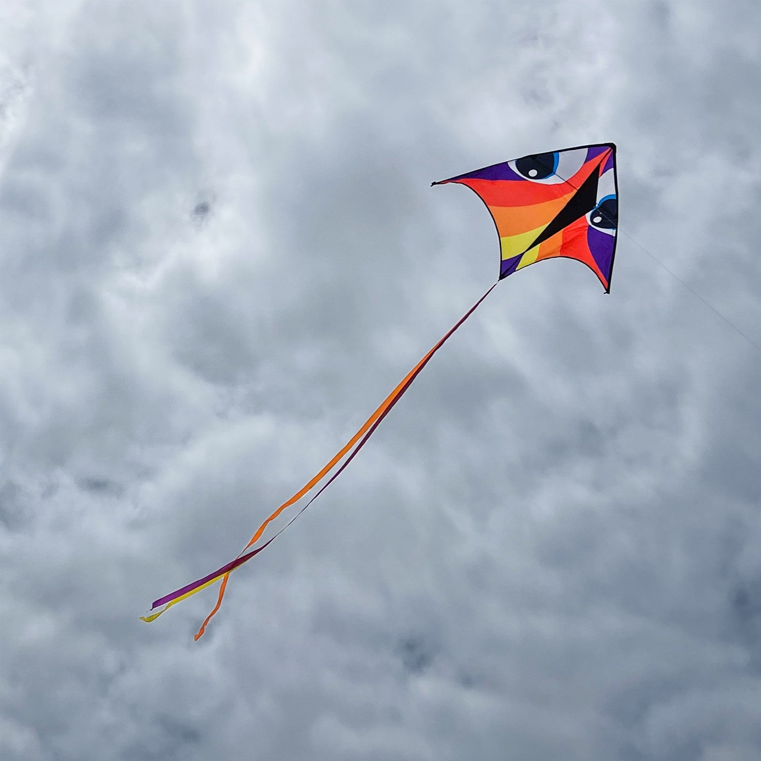 Vibrant Manu Red 72-inch Delta Kite soaring against a clear blue sky, complete with colorful accents and a 12-foot streamer tail.