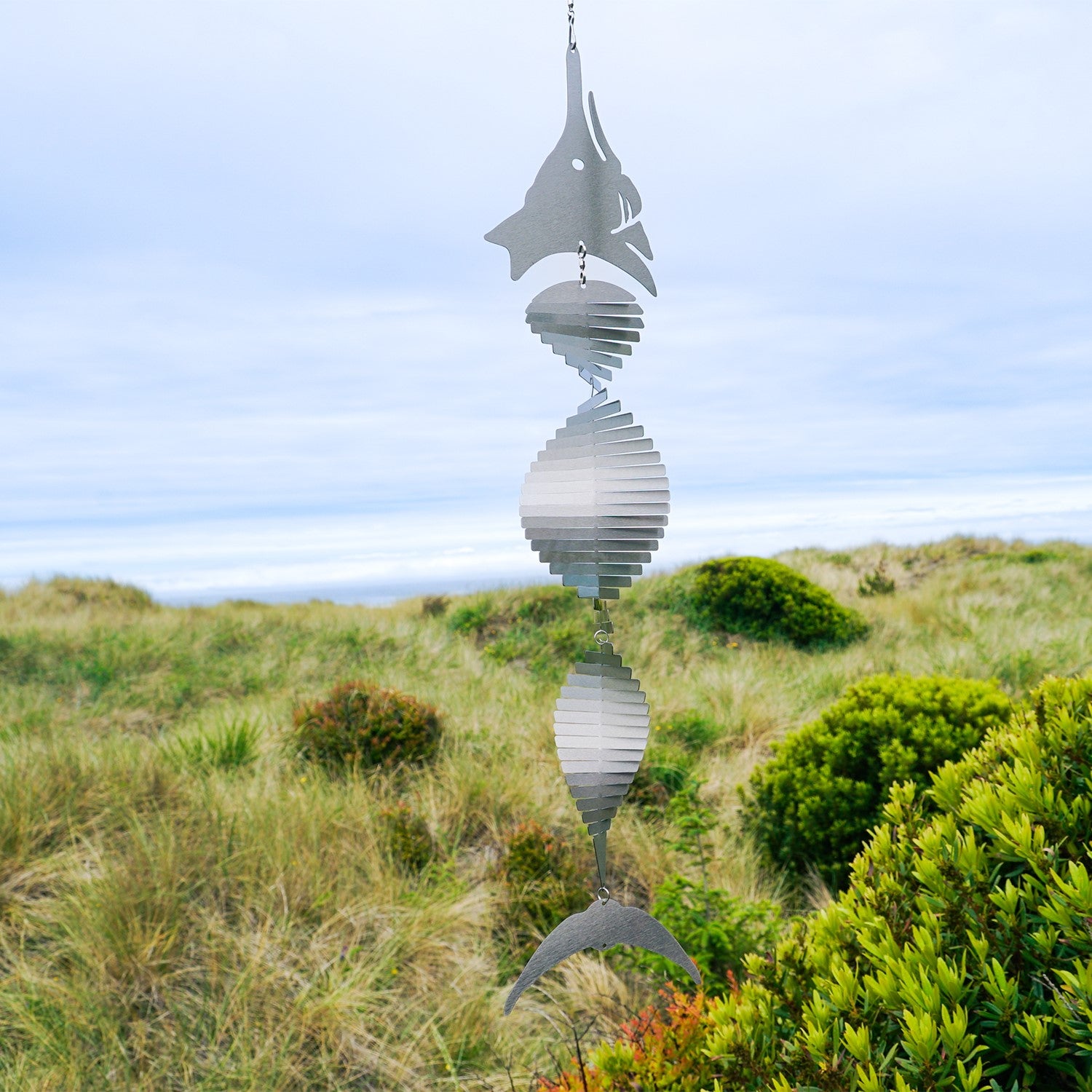 Visually striking Marlin Shimmer Helix Spinner with a helix design and reflective shimmering effect, crafted from durable stainless steel, elegantly displayed outdoors.