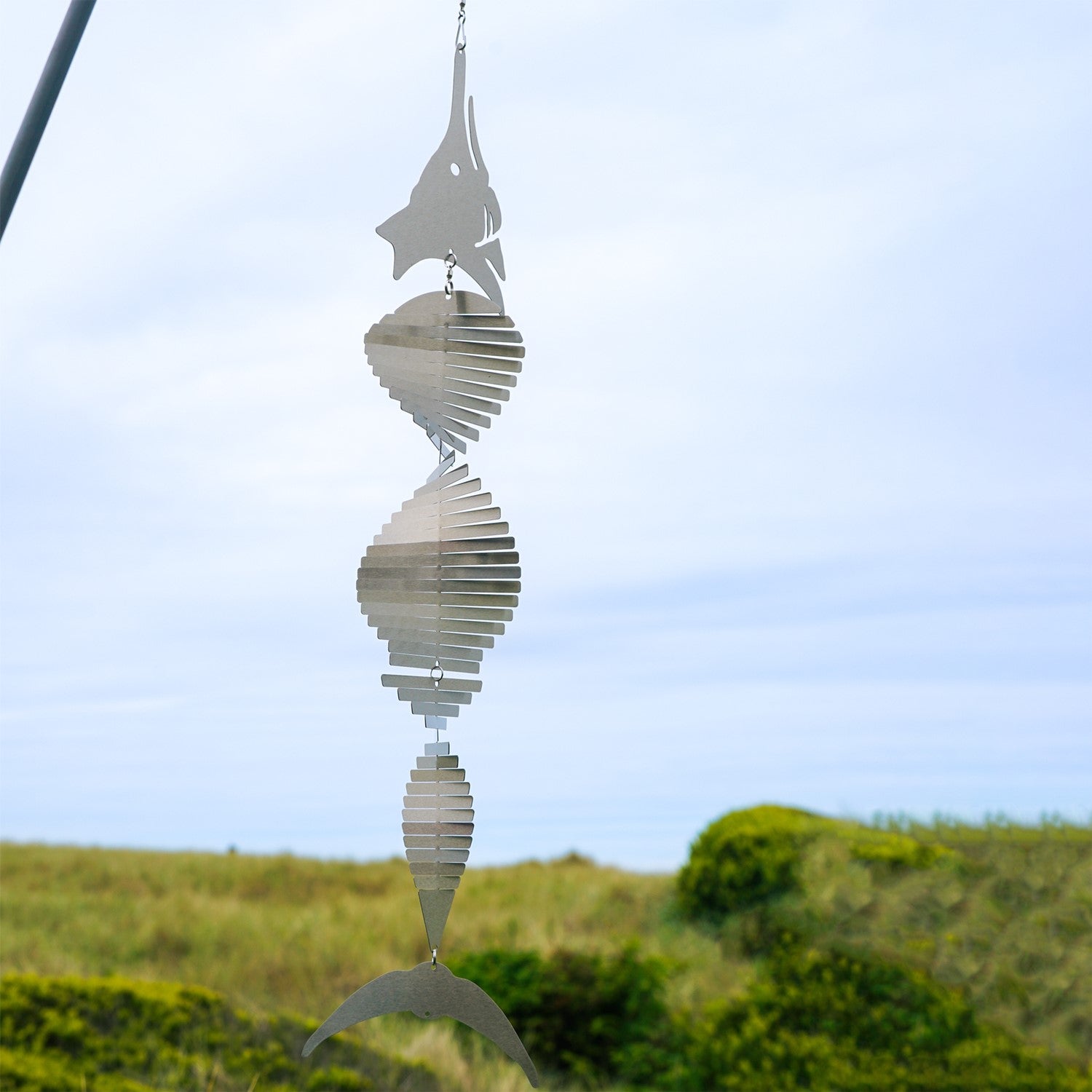 Visually striking Marlin Shimmer Helix Spinner with a helix design and reflective shimmering effect, crafted from durable stainless steel, elegantly displayed outdoors.