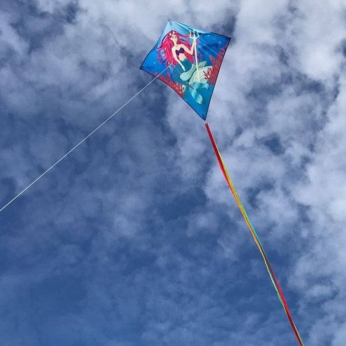 Mermaid 30" Diamond Kite flying in a clear blue sky, featuring bright colors and detailed graphics, ideal for kids and adults alike.
