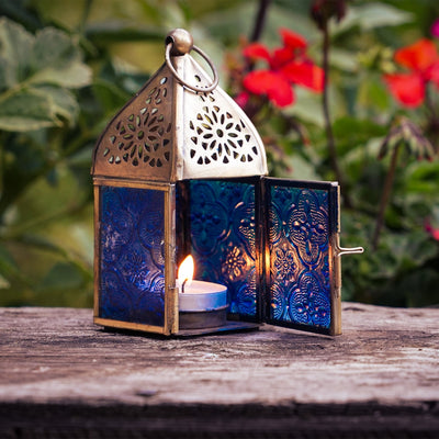 Mini Blue Square Glass Tealight Lantern with textured blue glass panels and a brass top, perfect for creating ambient lighting both indoors and outdoors.