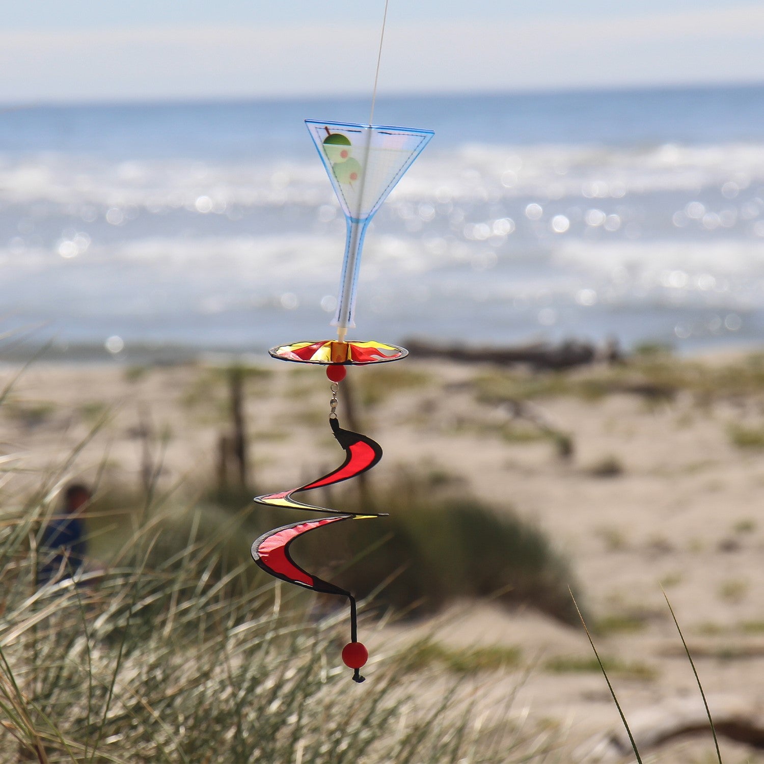 Mini Martini 5 O'Clock Drink Spinner that features a vibrant martini glass design, spinning gracefully in the outdoor breeze.