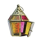 Mini Pink & Yellow Hex Glass Tealight Lantern featuring colorful stamped glass panels and a brass metal frame, displayed on a table illuminated by a candle.