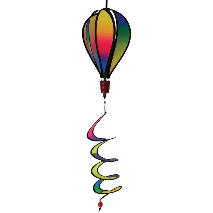 Mini Rainbow Blended Hot Air Balloon spinner with vivid colors floating gently in a garden setting, showcasing its joyful design and curlie tail.