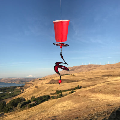 Mini Red Cup 5 O'Clock Drink Spinner featuring a vibrant solo cup design, spinning in the breeze, creating a cheerful outdoor atmosphere.