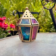 Mini Teal & Pink Hex Glass Tealight Lantern with textured glass and metal accents, radiating warm light in a cozy indoor setting.