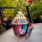 Mini Teal & Pink Hex Glass Tealight Lantern with textured glass and metal accents, radiating warm light in a cozy indoor setting.