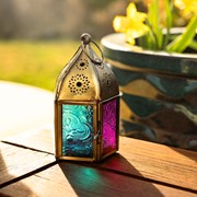 Mini Teal & Pink Pentagon Glass Tealight Lantern showcasing a vibrant design with textured glass panels and metal accents in a cozy indoor setting.