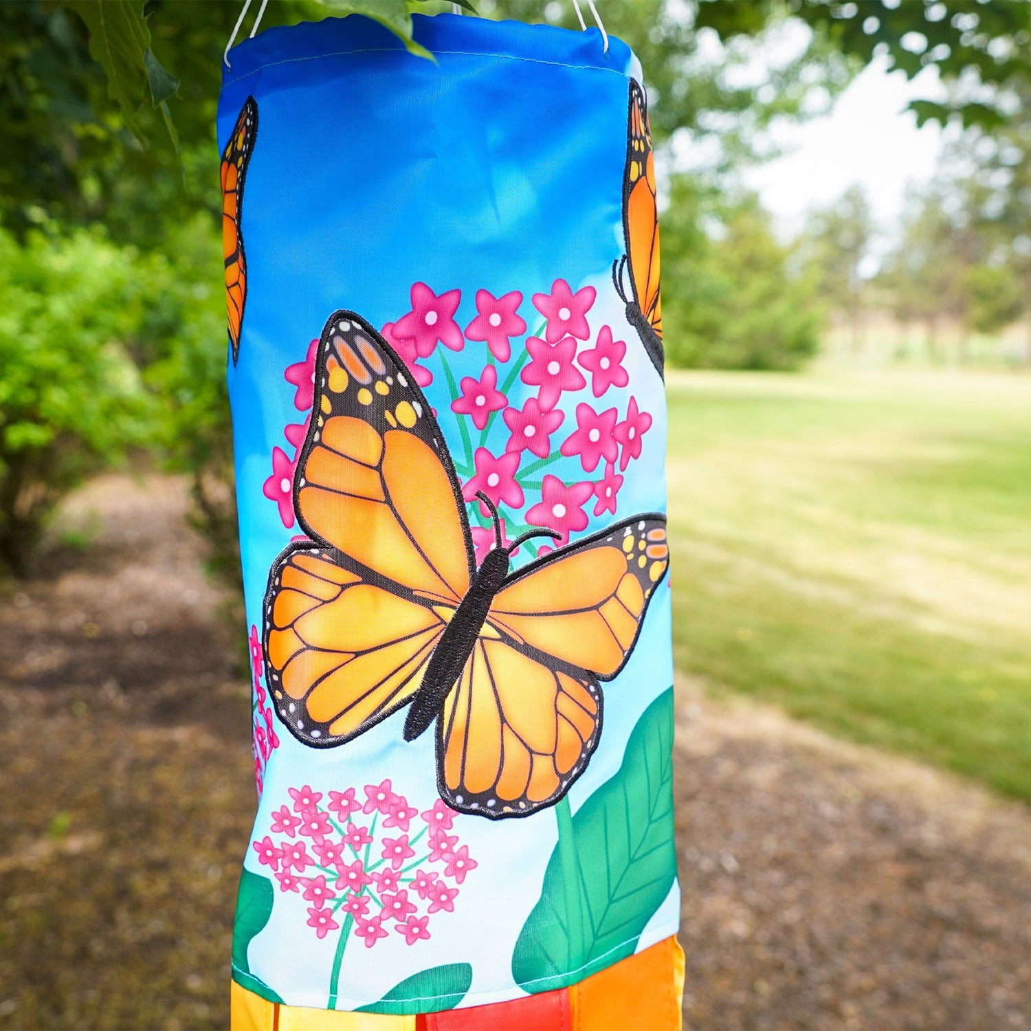 Monarch Butterfly 40" Inspiration Windsock featuring vibrant butterfly design and fluttering tails, displayed in an outdoor garden setting.