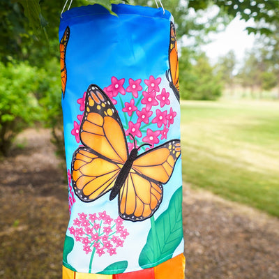 Monarch Butterfly 40" Inspiration Windsock featuring vibrant butterfly design and fluttering tails, displayed in an outdoor garden setting.