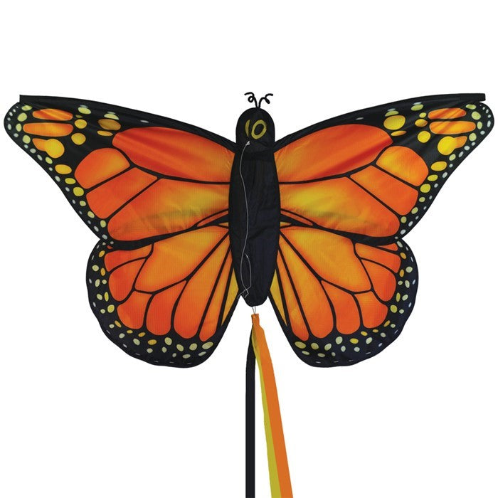 Monarch Butterfly Kite in vibrant orange and red colors soaring against a blue sky with tails fluttering gracefully behind it.
