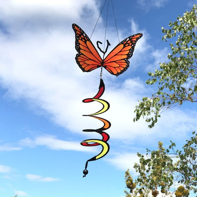 Monarch Butterfly Theme Twister featuring moveable wings and a curlie tail, hanging gracefully in a vibrant outdoor garden setting.