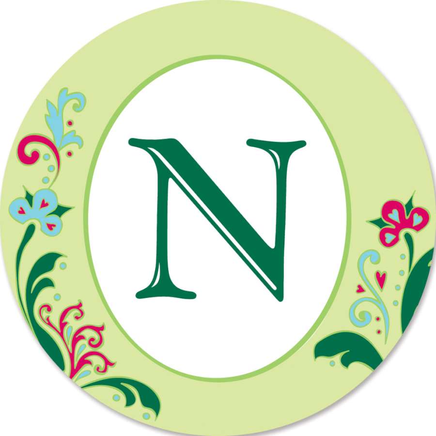 Monogram Triple Spinner - N, featuring vibrant colors and spinning design displayed in a lush garden, creating an eye-catching outdoor decoration.