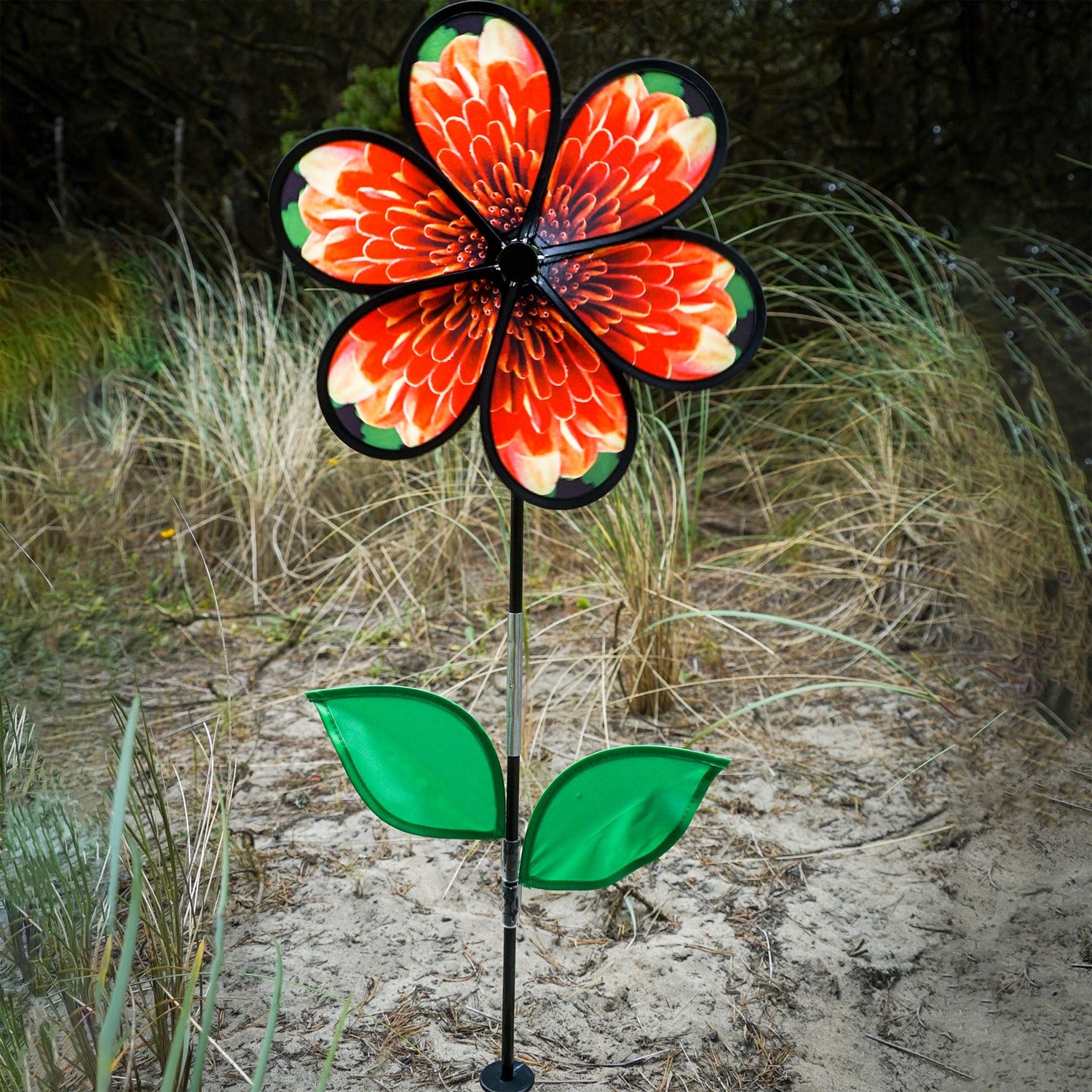 13.5-inch Mum Spinner with Leaves featuring realistic chrysanthemum petals and green leaves, spinning in a garden setting.