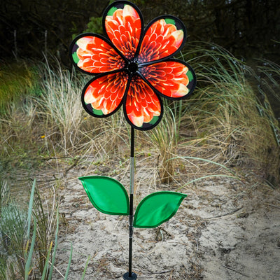 13.5-inch Mum Spinner with Leaves featuring realistic chrysanthemum petals and green leaves, spinning in a garden setting.