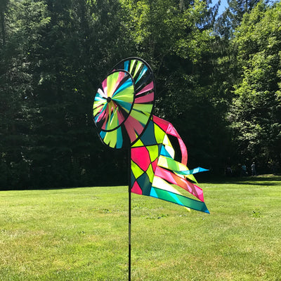 Neon Colorblock Spinner Wheels with colorful garden flag and tails spinning in the breeze, adding lively decor to an outdoor space.