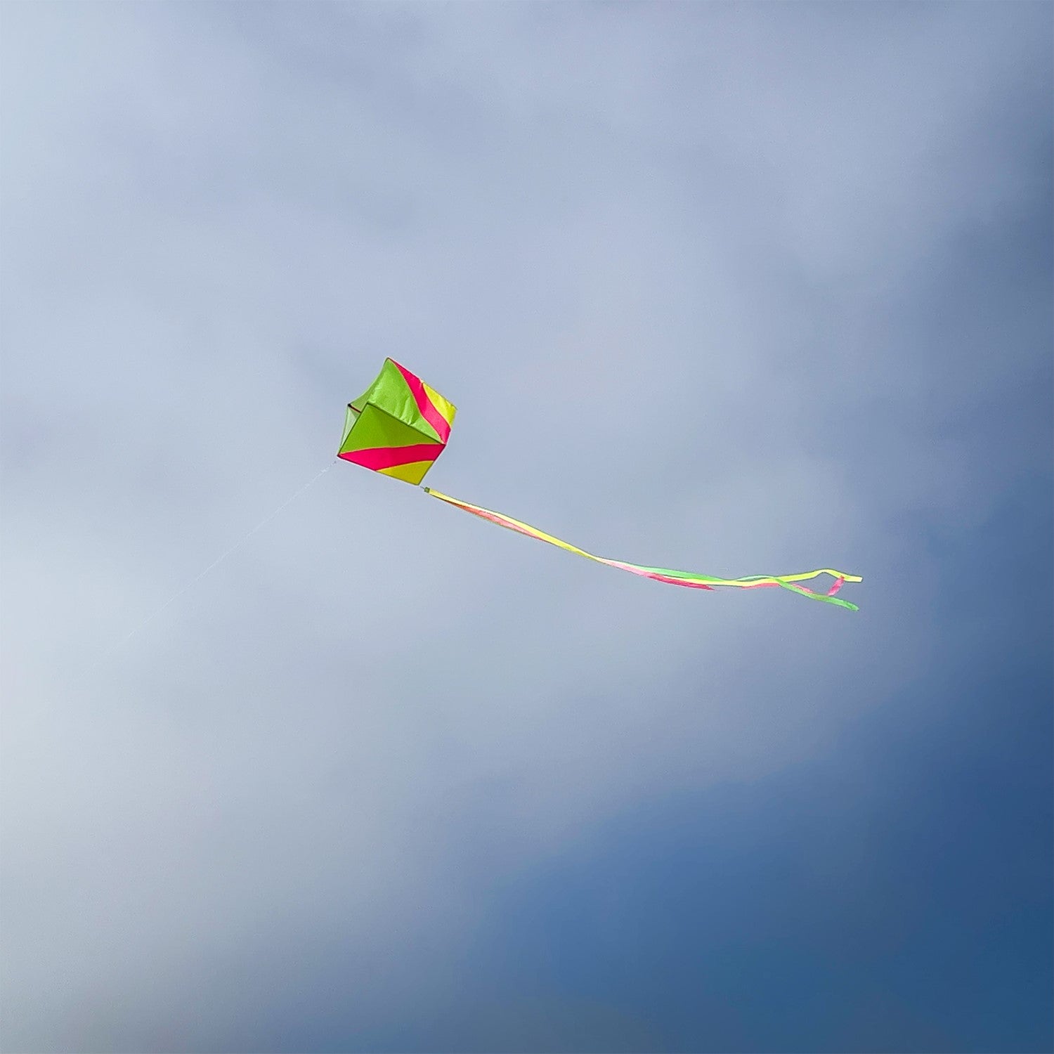 Vibrantly colored Neon Single Box Kite soaring in the sky with color-coordinated tails, designed for easy flying and fun.