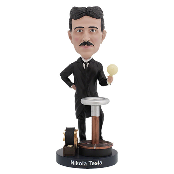 Nikola Tesla Bobblehead figurine capturing Tesla's likeness, detailed with hand-painted features, displayed on a desk among books.