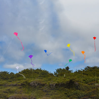 Orange Colorfly 30" Diamond Kite with vivid orange color and three 12' tails displayed in the sky during a sunny day, signifying outdoor fun.
