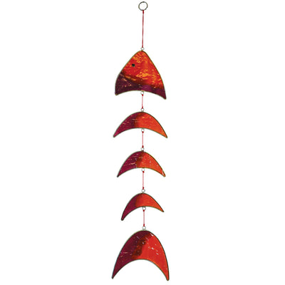Colorful orange and purple resin fish mobile hanging outdoors, with translucent blocks that reflect sunlight beautifully in a garden setting.