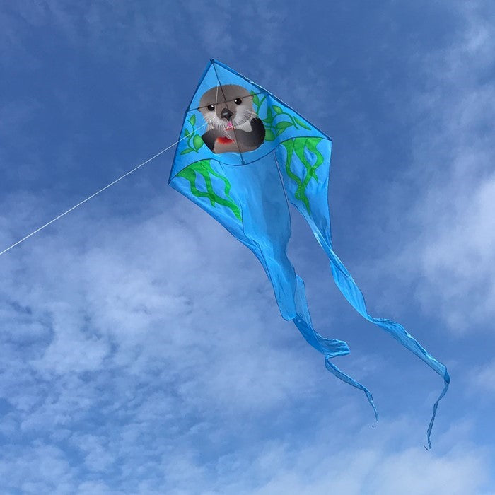 Otter 52' Wave Delta Kite with playful otter design soaring against a bright blue sky, showcasing its vibrant colors and flowing tails.