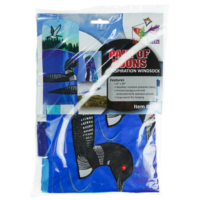 Pair of Loons 40-inch Inspiration Windsock displayed outdoors, featuring bright colors, detailed loons, and fluttering tails in a serene garden setting.