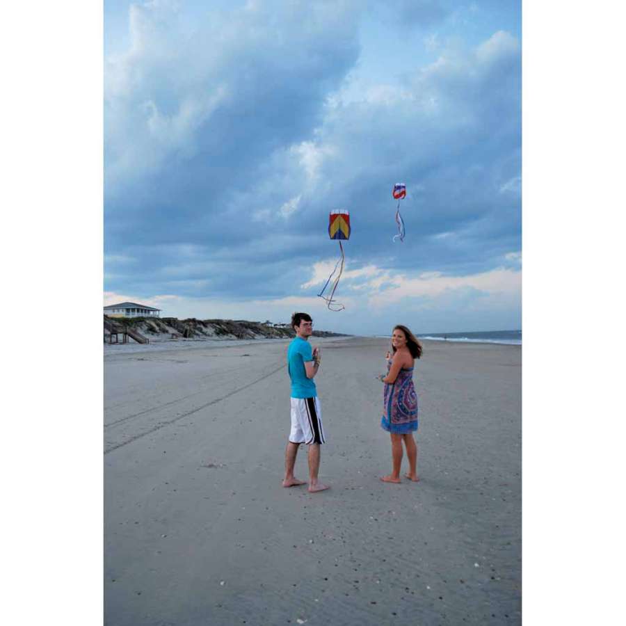 Parafoil 5 Kite in rainbow colors flying against a clear blue sky, measuring 20 x 32 inches, showcasing its vibrant design and streamer tail.
