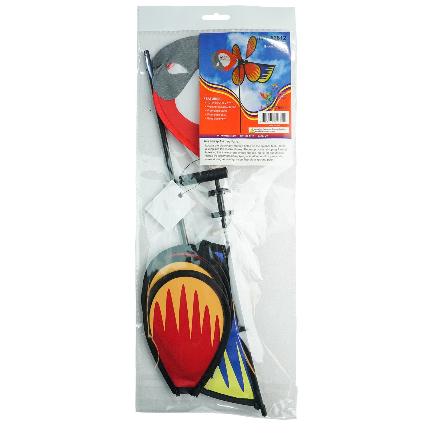 Parrot Baby Spinner featuring bright colors and detailed graphics, spinning easily on a 17-inch fiberglass pole in a garden setting.