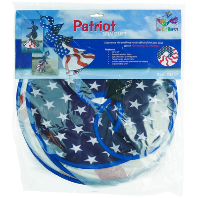 Patriot Spin Duet double spinner decoration featuring red, white, and blue stars and stripes design hanging outdoors in a garden setting.