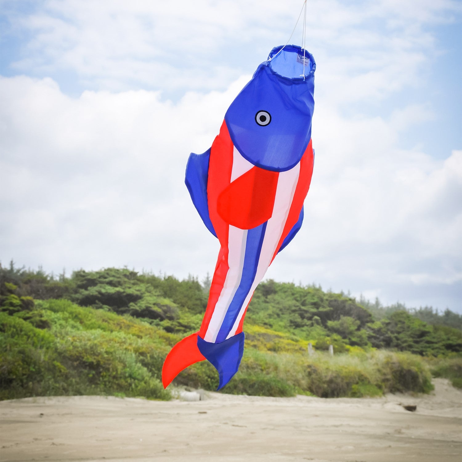 Patriot Trout 48" Fishsock in vibrant red, white, and blue swaying in the breeze from a hanging point in a garden setting.
