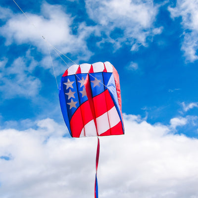 7.5 Patriot Wave Air Foil Kite soaring in the sky with red, white, and blue colors and stars, showcasing its lightweight design and beauty.
