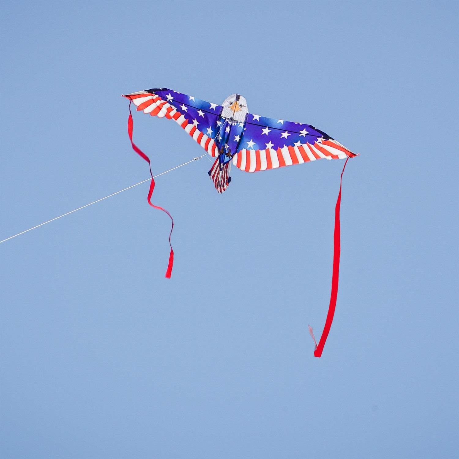 40-inch Patriotic Bald Eagle Bitty Bird Kite with a realistic eagle head and American flag body, displayed flying against a clear blue sky.