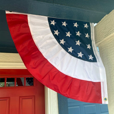 Patriotic Ruffle Corner Bunting set of 2 featuring red, white, and blue colors with embroidered stars displayed on a porch railing for outdoor decoration.