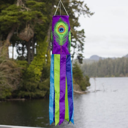 Peacock Feather 40" Windsock shown outdoors, fluttering in the breeze, adding vibrant color and motion to any garden or outdoor space, ideal for decor enthusiasts.