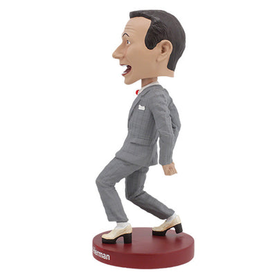 Pee-Wee Herman Bobblehead, standing 7 inches tall in a gray suit and red bowtie, featuring a playful expression, displayed on a decorative shelf.