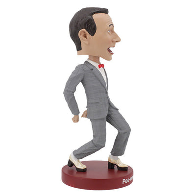 Pee-Wee Herman Bobblehead, standing 7 inches tall in a gray suit and red bowtie, featuring a playful expression, displayed on a decorative shelf.