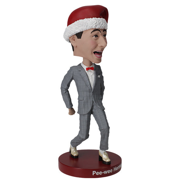 Pee-Wee Herman Holiday Bobblehead featuring the character in a gray suit and red bowtie, standing approximately 7 inches tall on a display surface.