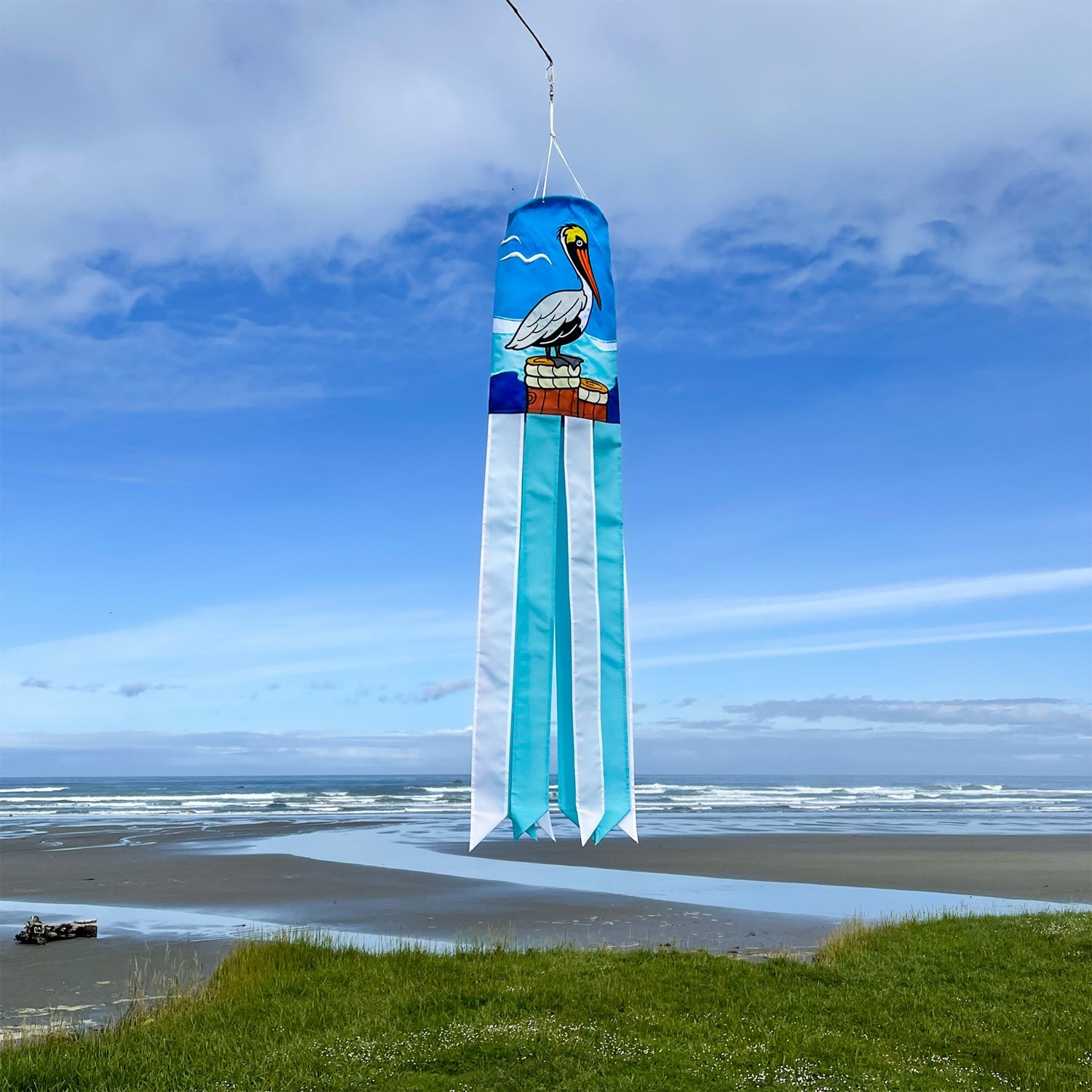 Pelican 40" Windsock showcasing a colorful pelican design with fluttering tails, displayed outdoors against a sunny backdrop.