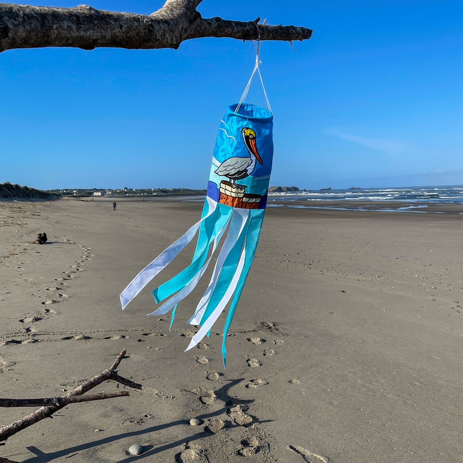 Pelican 40" Windsock showcasing a colorful pelican design with fluttering tails, displayed outdoors against a sunny backdrop.