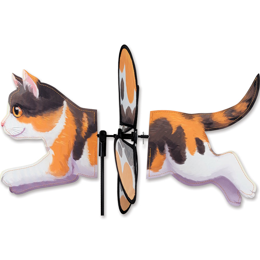 Petite Spinner featuring a calico cat design, displaying its vibrant colors while spinning in a charming garden setting.