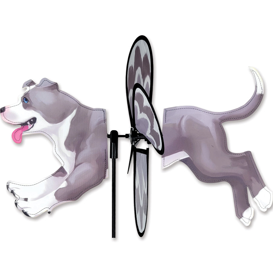 Petite Spinner featuring a colorful pit bull design, spinning gracefully in a garden setting under clear skies.