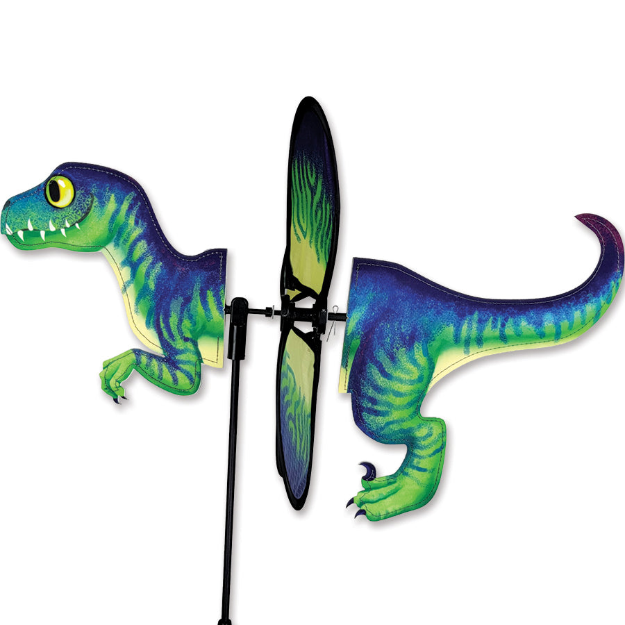 Petite Spinner - Velociraptor features vibrant colors and a charming dinosaur design, spinning in the wind in a sunny garden setting.