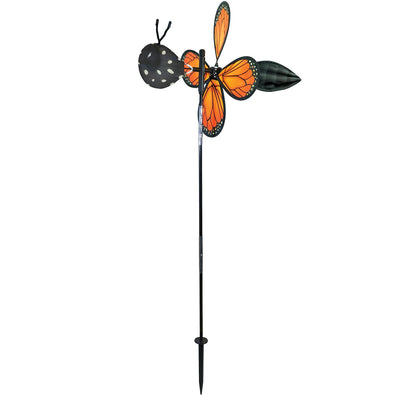Vibrant Pivoting Monarch Butterfly Spinner in a garden, showcasing colorful petal design and fiberglass frame, adding motion to the outdoor space.