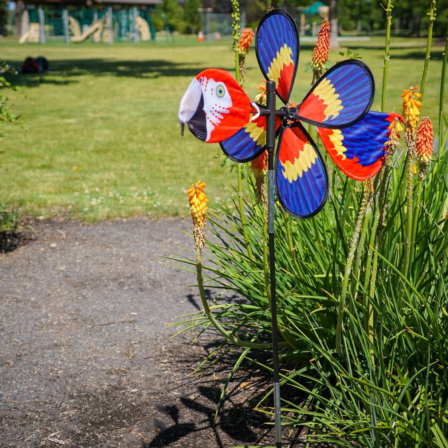 The Pivoting Parrot Bird Spinner showcases a vivid design of a parrot, spinning gracefully in the wind, adding a splash of color to your outdoor space.